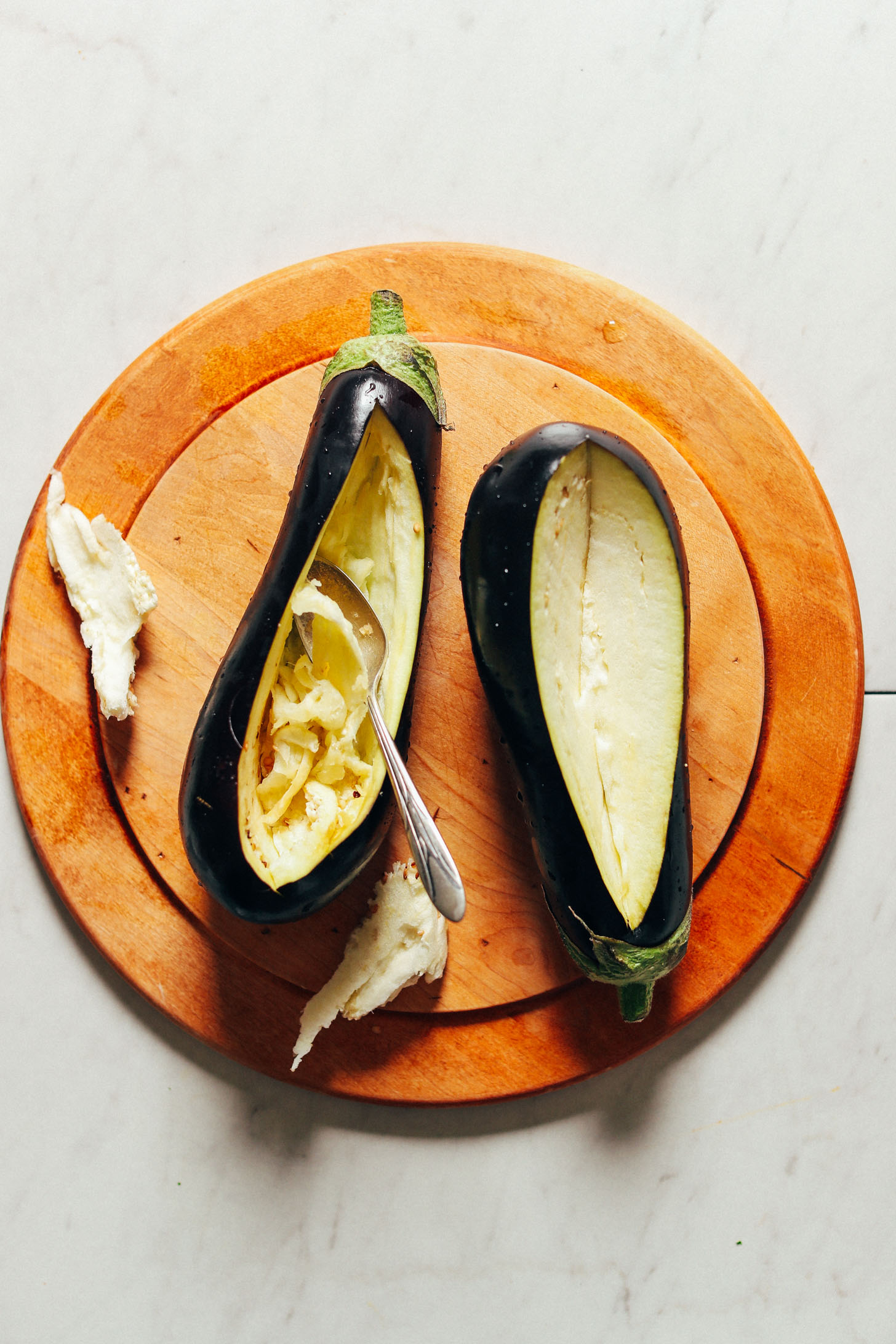Scooping out flesh from eggplants for making Moroccan Lentil-Stuffed Eggplant