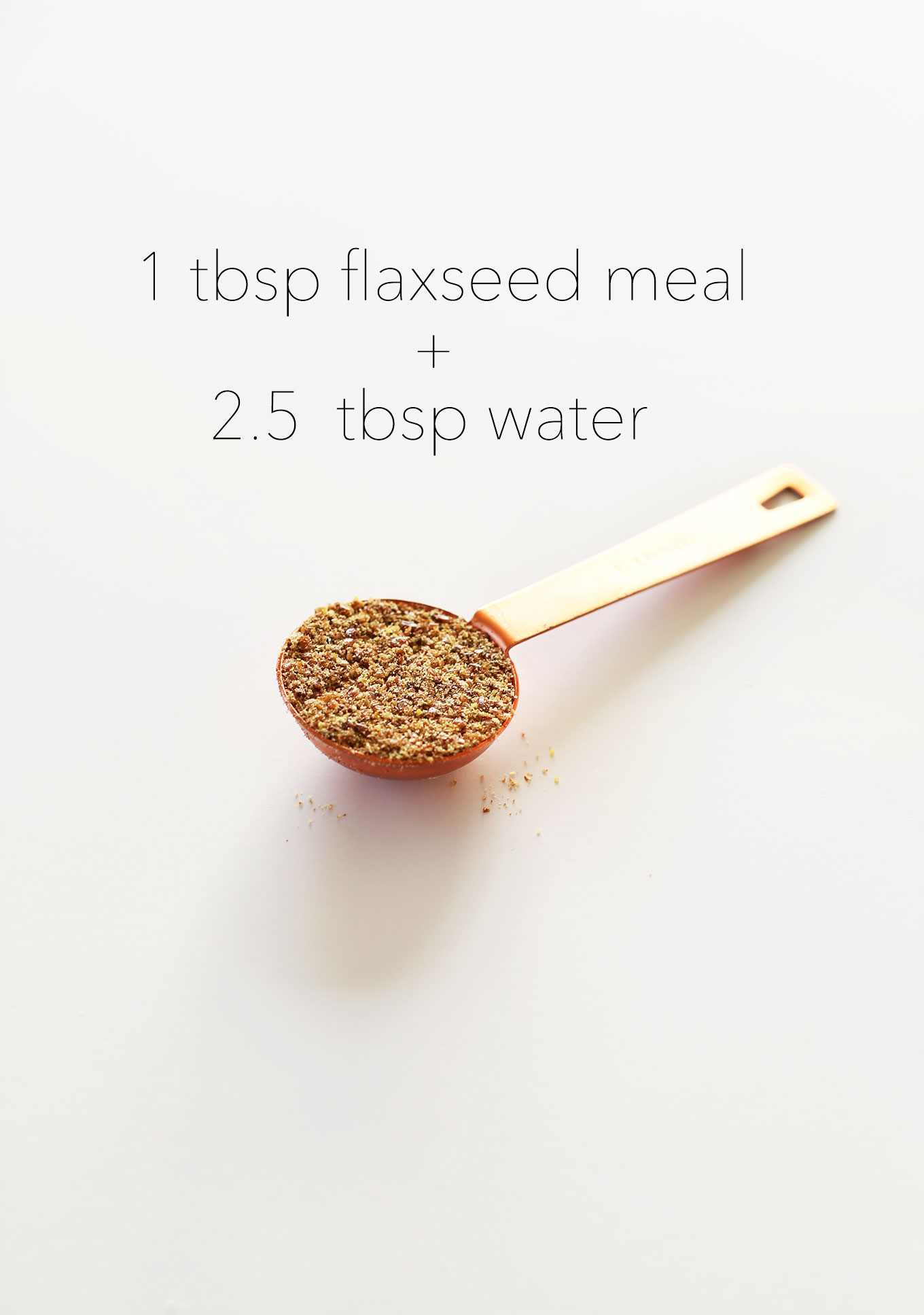 Measuring spoon filled with flaxseed meal for our How to Make a Flax Egg tutorial